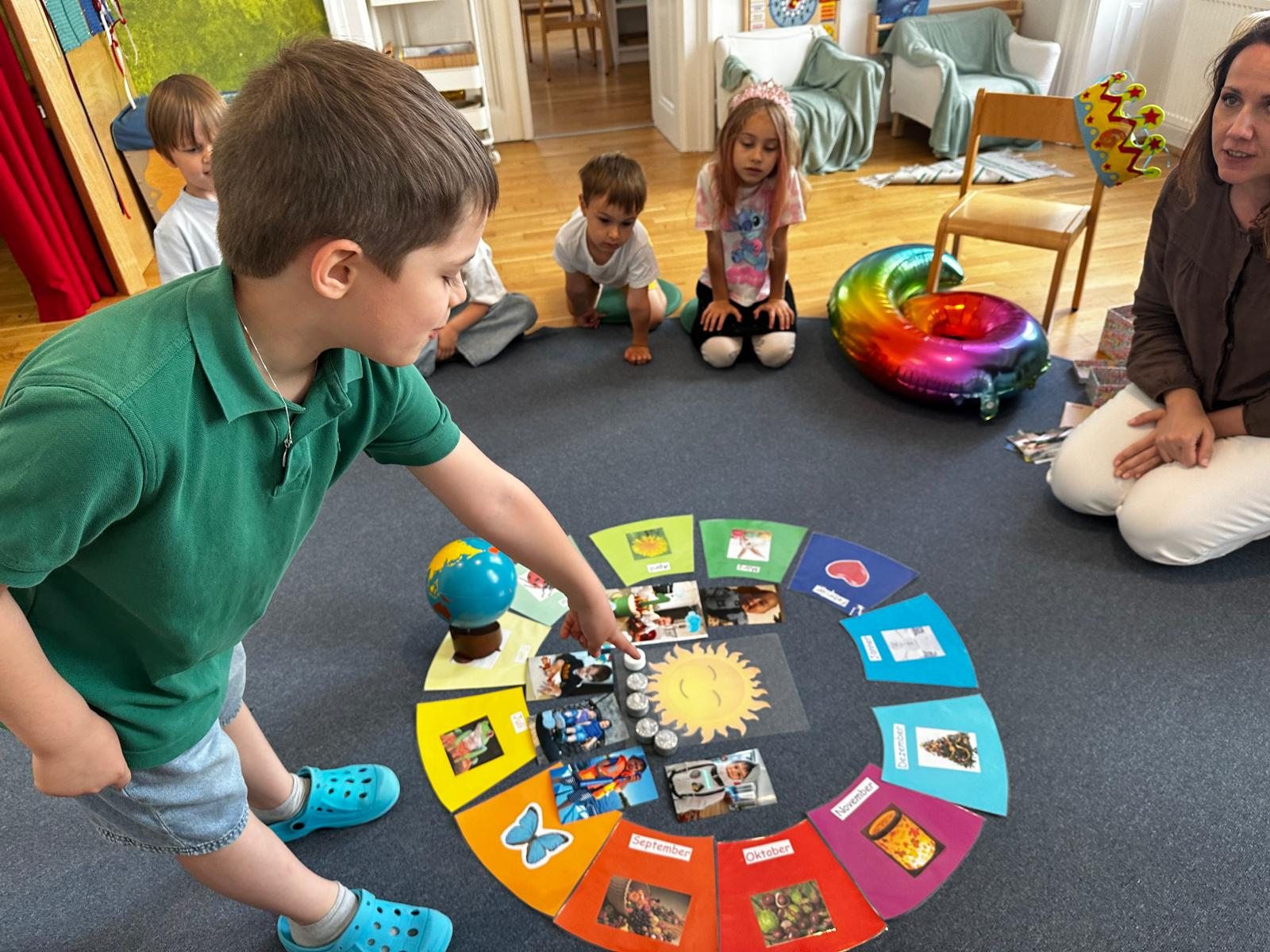 Kinder entdecken im Sitzkreis einen Jahreskreis mit Bildern